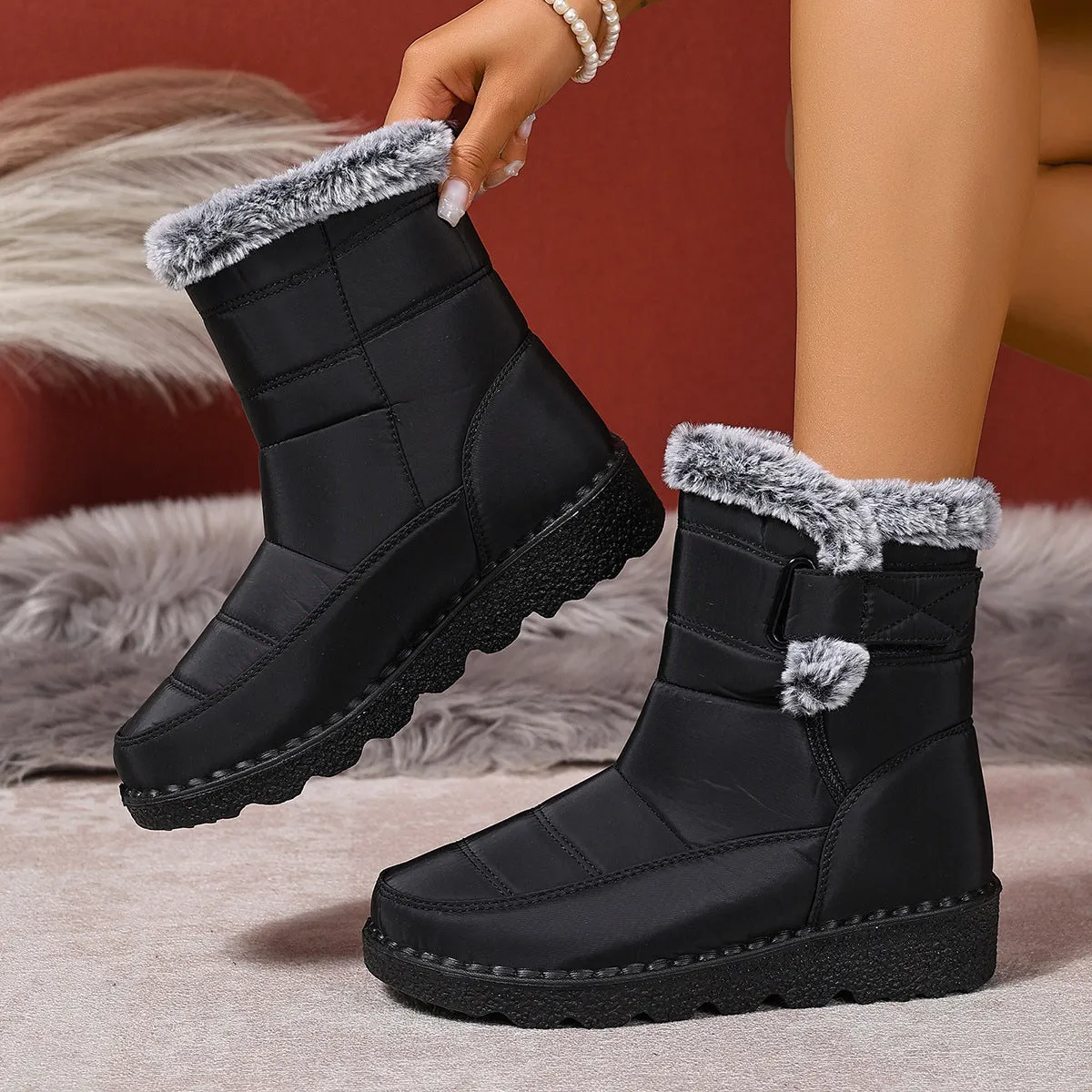 Women's snow boots in black with buckle fastening and round toe