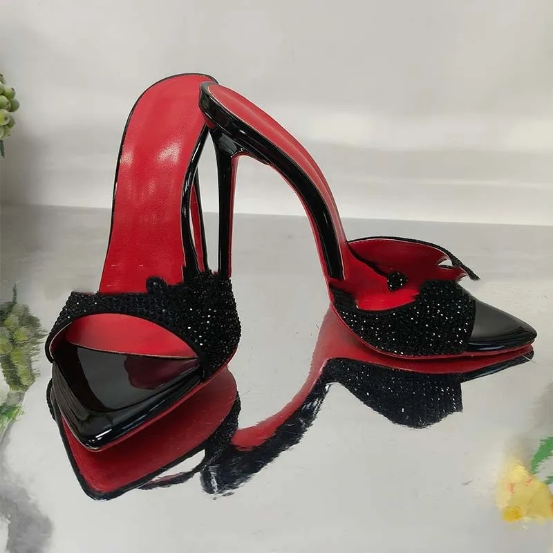 Black rhinestone ankle-strap open toe sandal with super high heel and pointed toe on white background