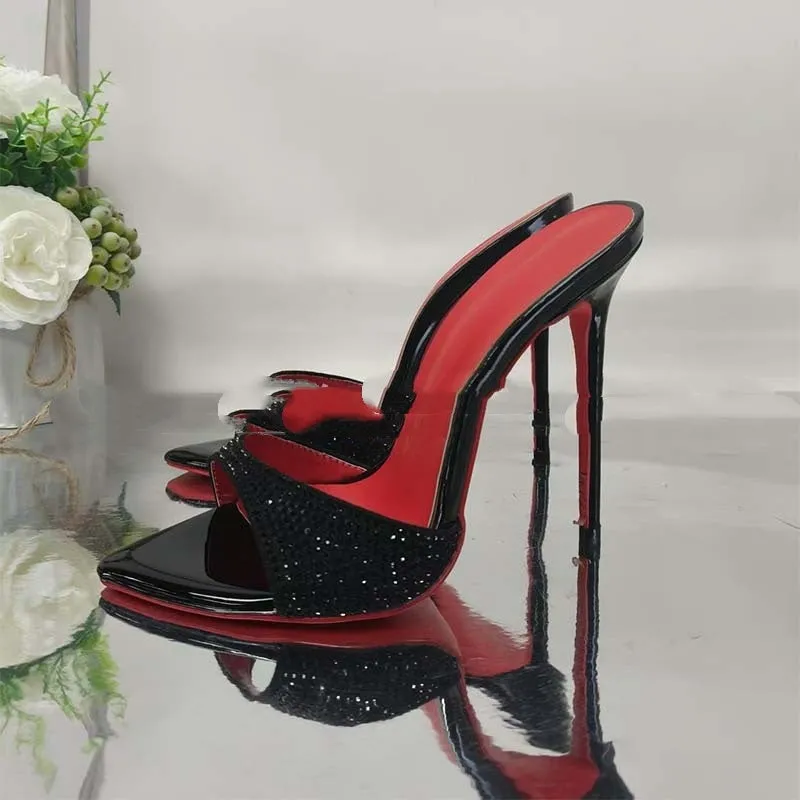 Black rhinestone ankle-strap open toe sandal with super high heel and pointed toe on white background