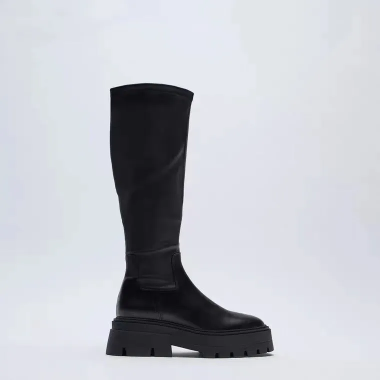 Women's black high leg stretch boots with round toe, non-slip rubber sole, and mid heel on a clean background.