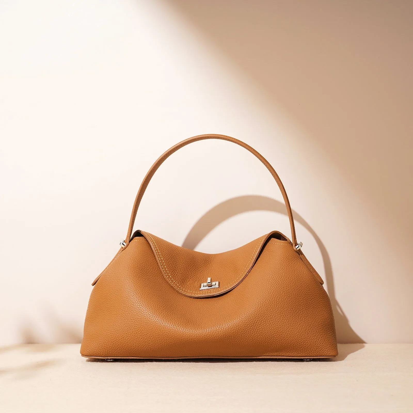 Cowhide leather shoulder messenger bag in pillow shape with open pocket, available in five colours including black and golden brown.