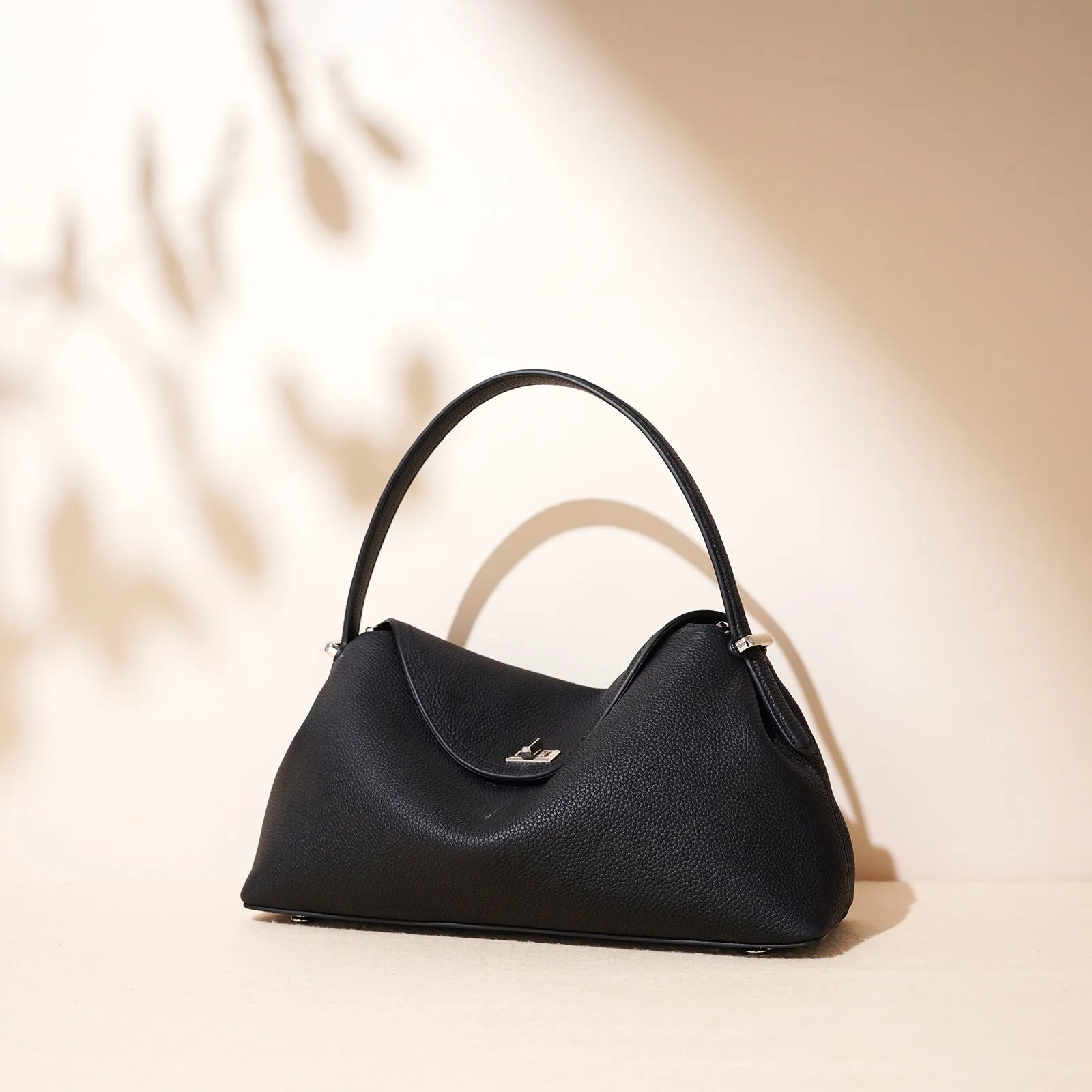 Cowhide leather shoulder messenger bag in pillow shape with open pocket, available in five colours including black and golden brown.