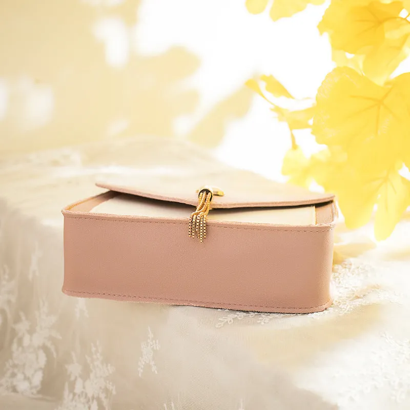 Small square PU leather crossbody bag with cat tassel decoration, magnetic flap, and adjustable chain strap in black