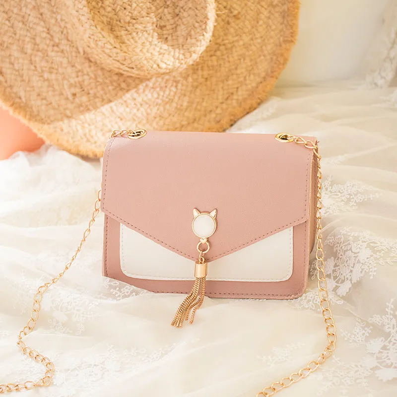 Small square PU leather crossbody bag with cat tassel decoration, magnetic flap, and adjustable chain strap in black