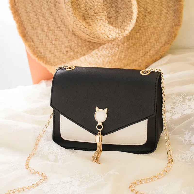 Small square PU leather crossbody bag with cat tassel decoration, magnetic flap, and adjustable chain strap in black