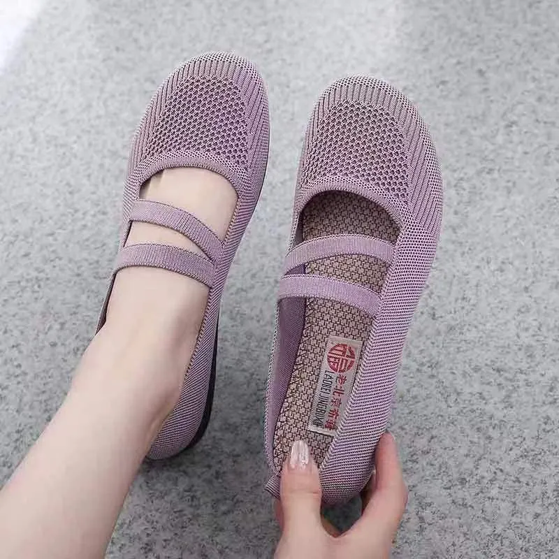 A pair of casual slip-on flat shoes with a round toe and elastic fabric upper, shown in an embroidered colour option.