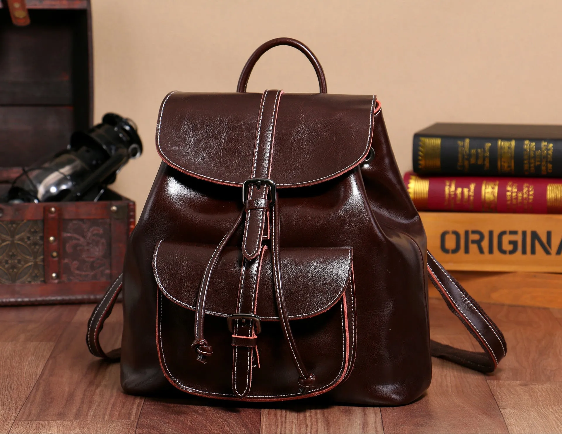 Korean style brown cowhide leather backpack with pull-belt fastening and front sandwich pocket.
