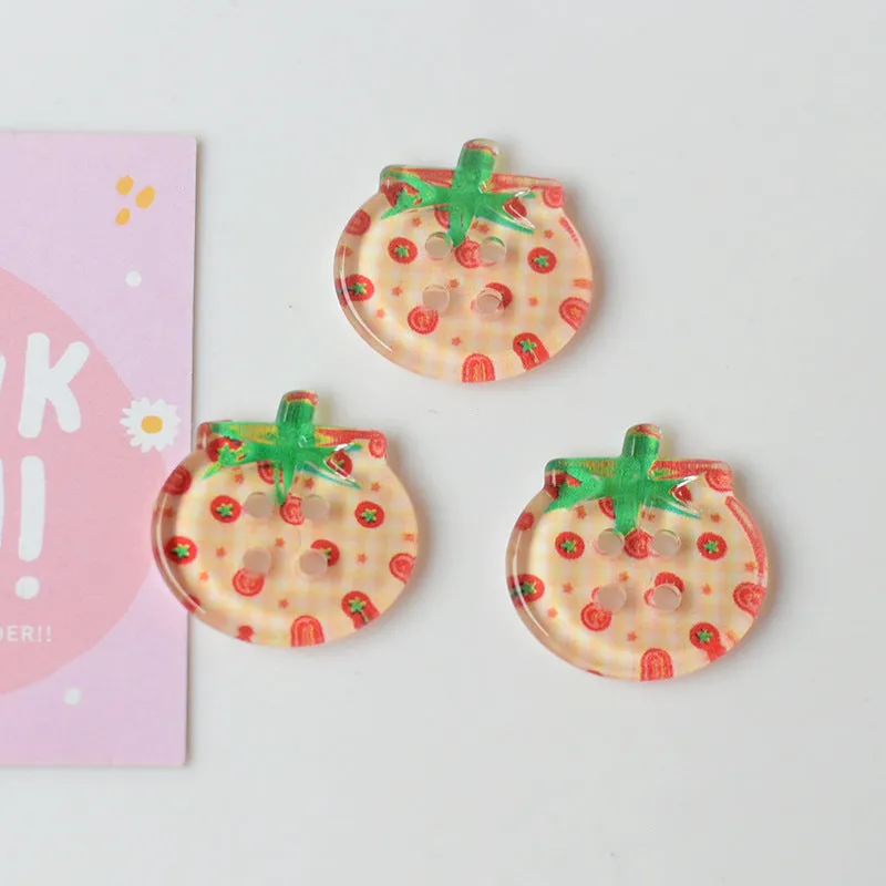 A pack of medium-sized plastic tomato button ornaments in mixed colours including red plaid and cherry tomato print.