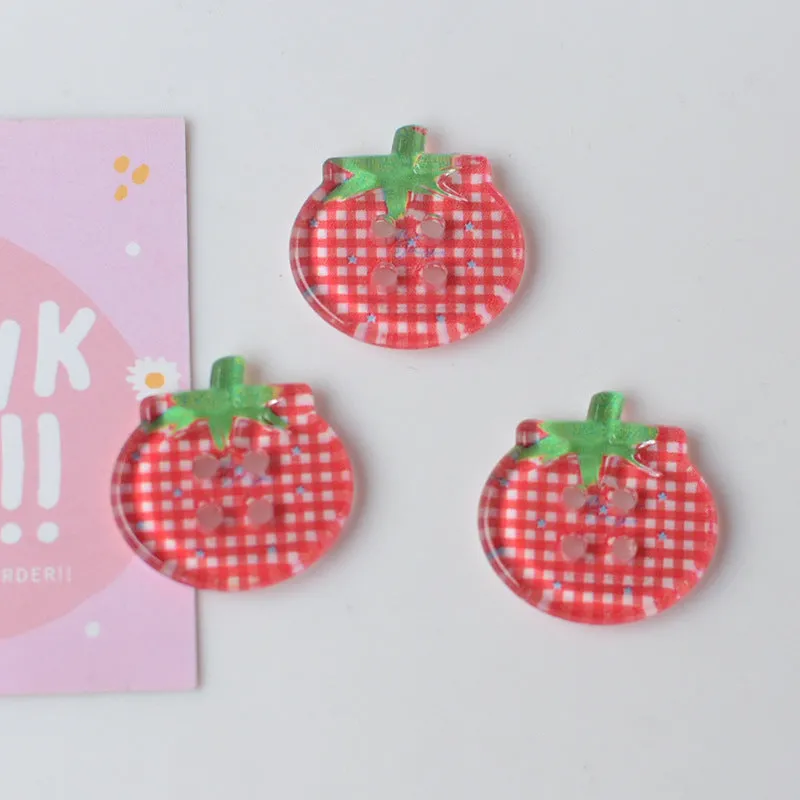 A pack of medium-sized plastic tomato button ornaments in mixed colours including red plaid and cherry tomato print.