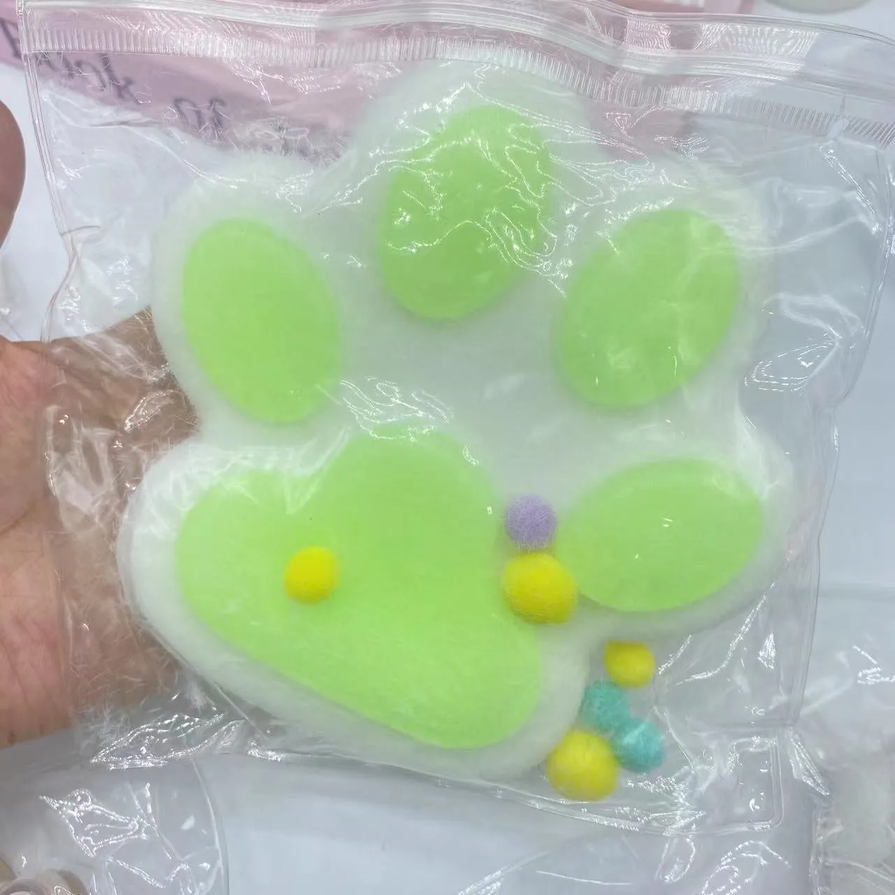 Oversized plush cat's paw squeezing toy in 14cm TPR flocking finish, black colour, on white background