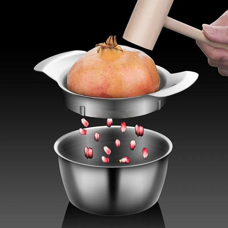 Stainless steel pomegranate fruit opener tool with optional bowl and wooden hammer on a kitchen counter.