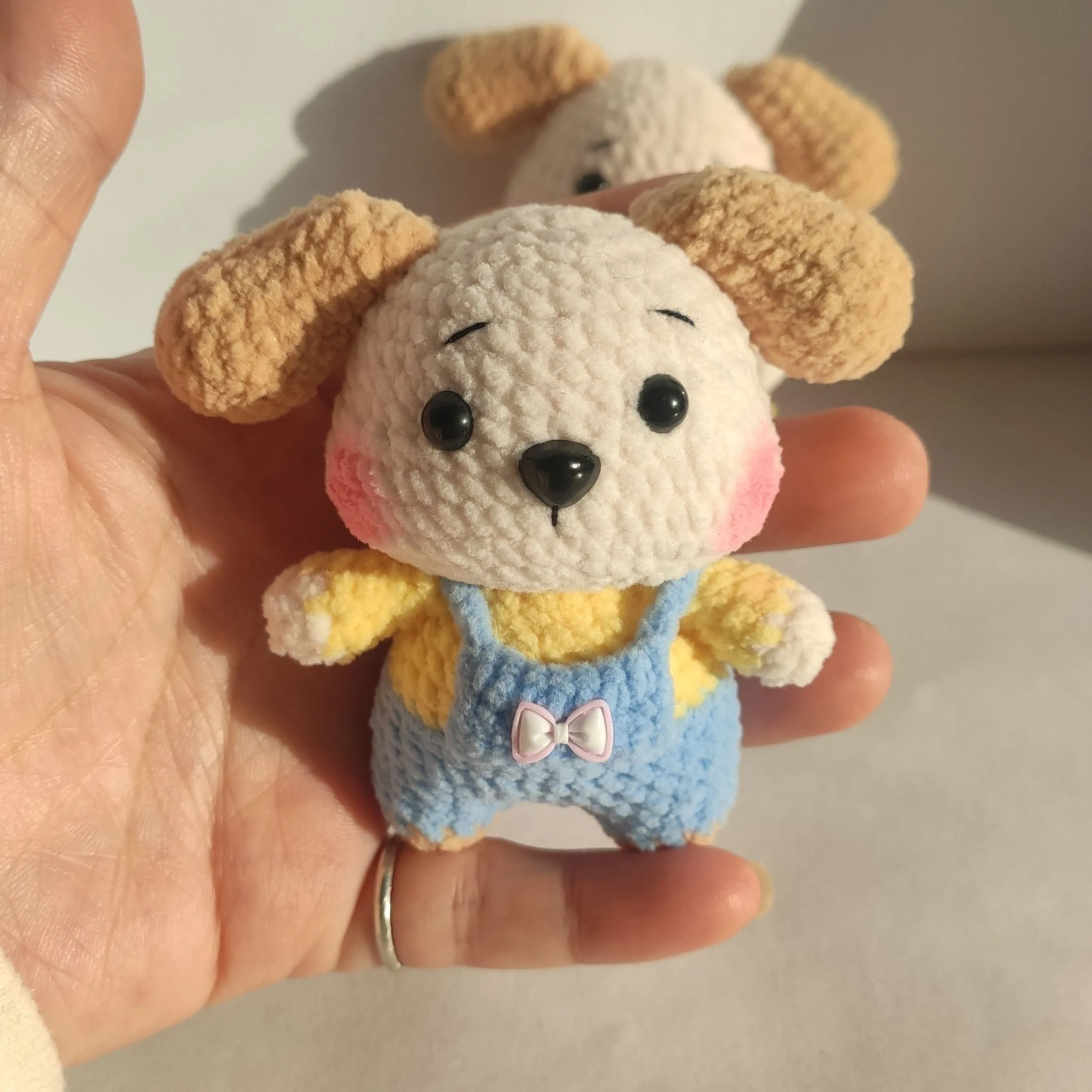Handmade woollen zodiac dog pendant charm on a keychain, shown in pinafore dress style.