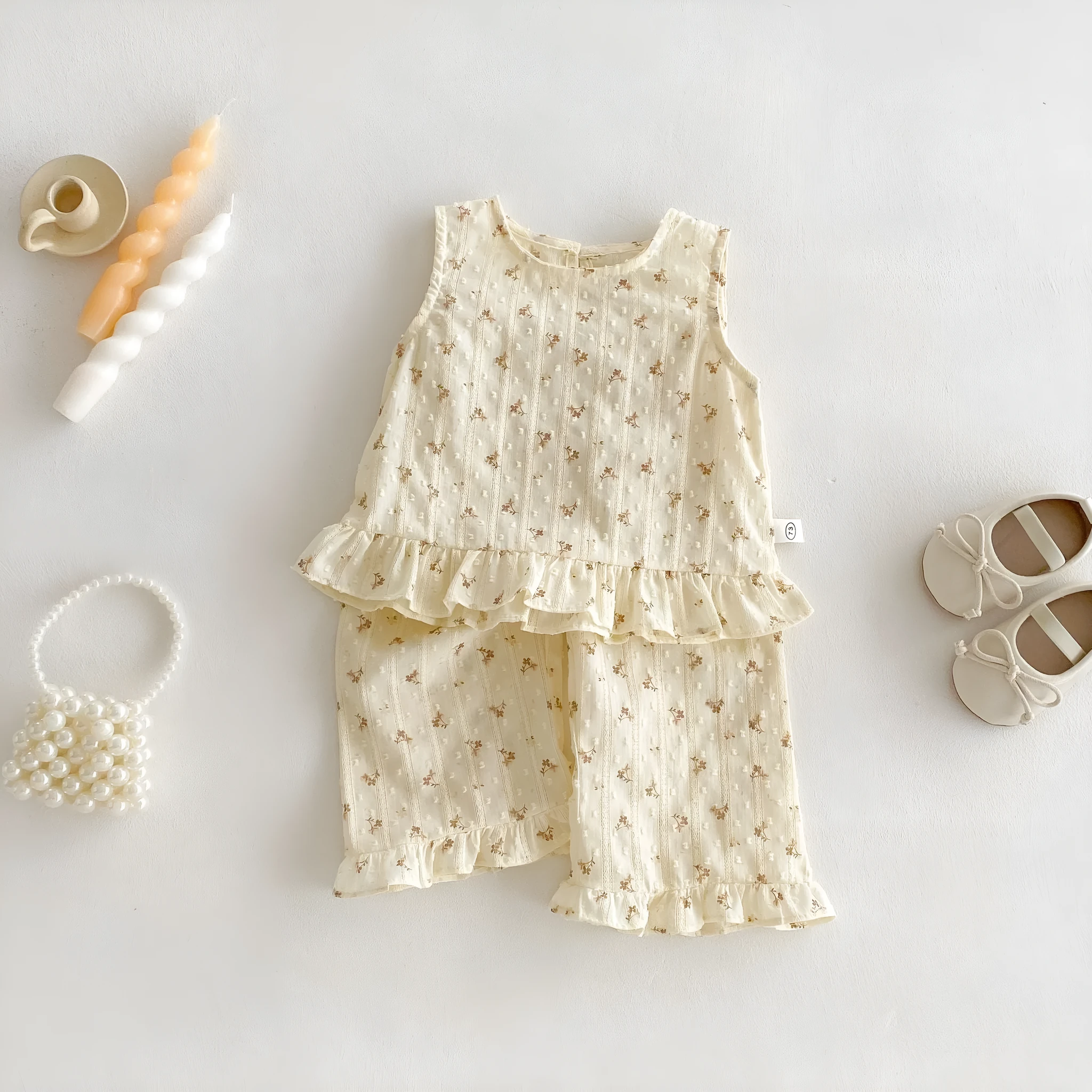 Children's cotton sleeveless top and trousers two-piece set in cream apricot on white background