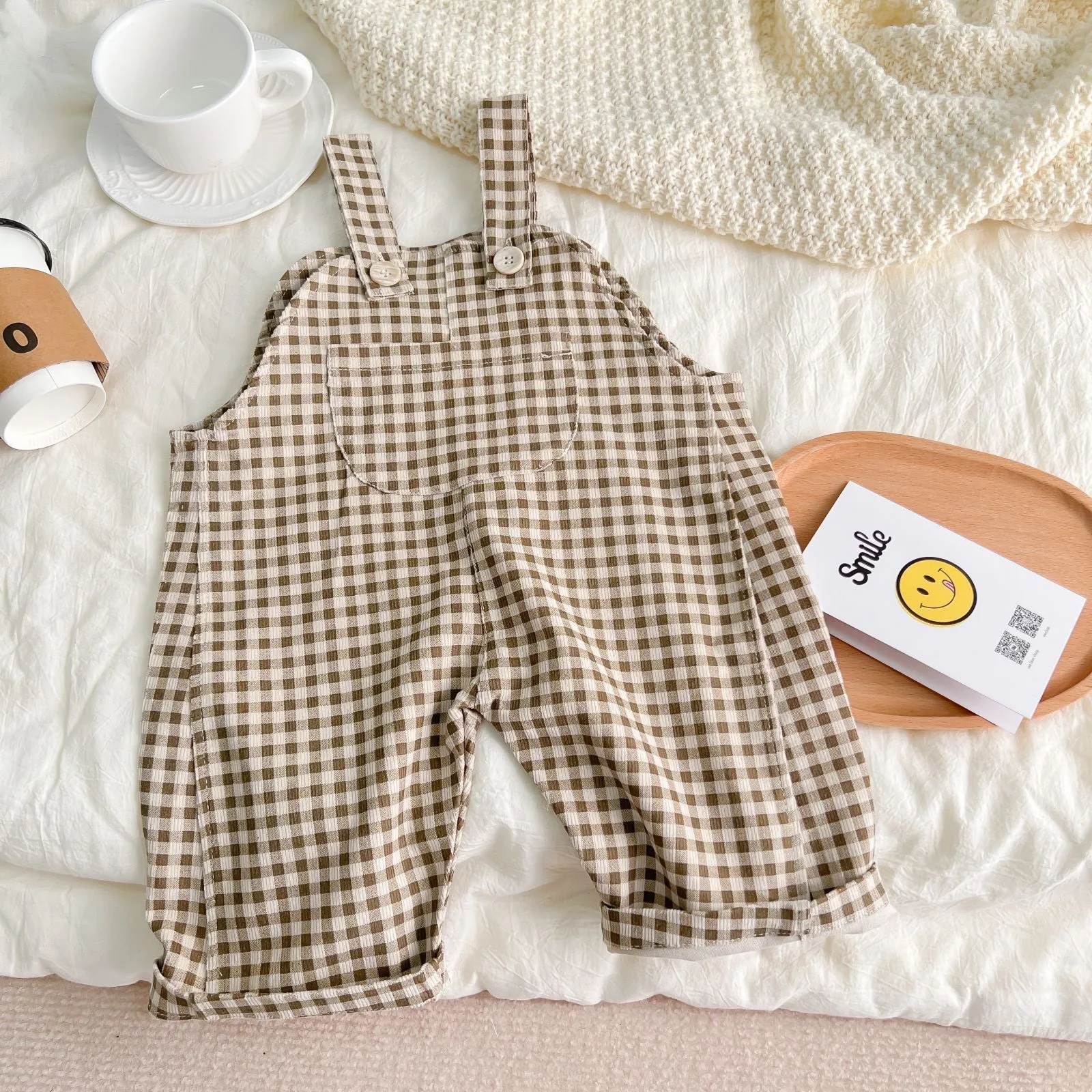Infant cotton corduroy overalls in creamy white with large front pockets and double-breasted closure