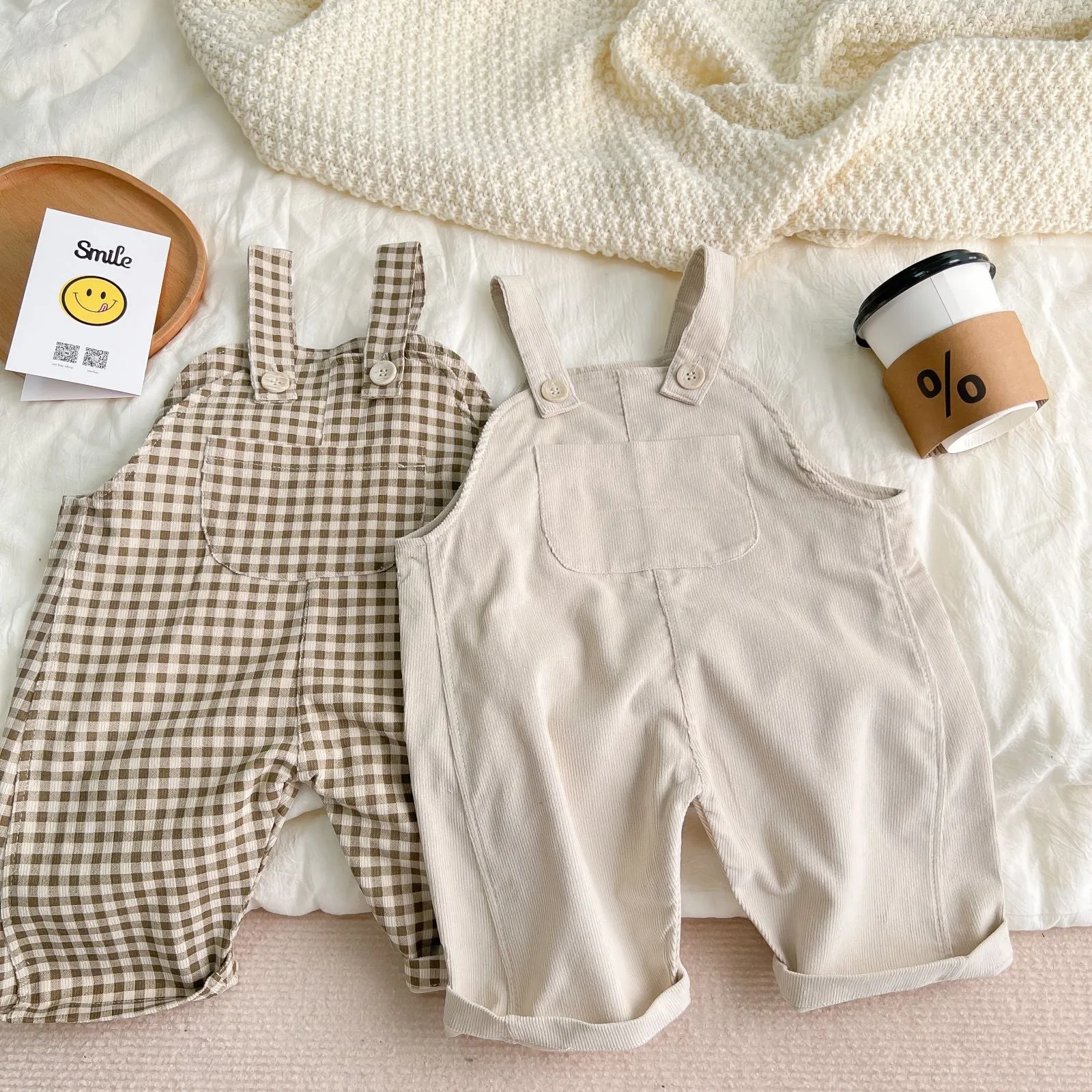 Infant cotton corduroy overalls in creamy white with large front pockets and double-breasted closure
