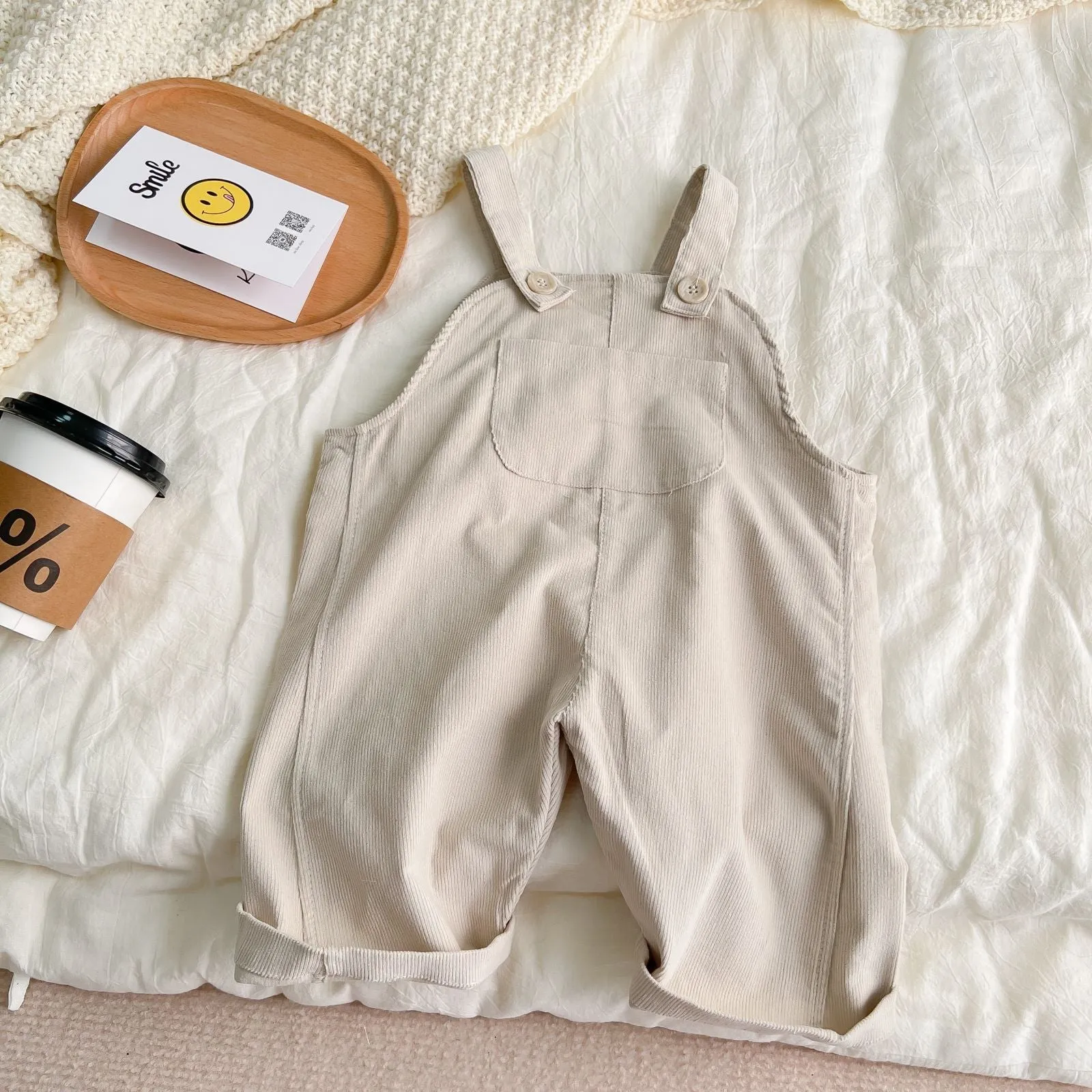 Infant cotton corduroy overalls in creamy white with large front pockets and double-breasted closure