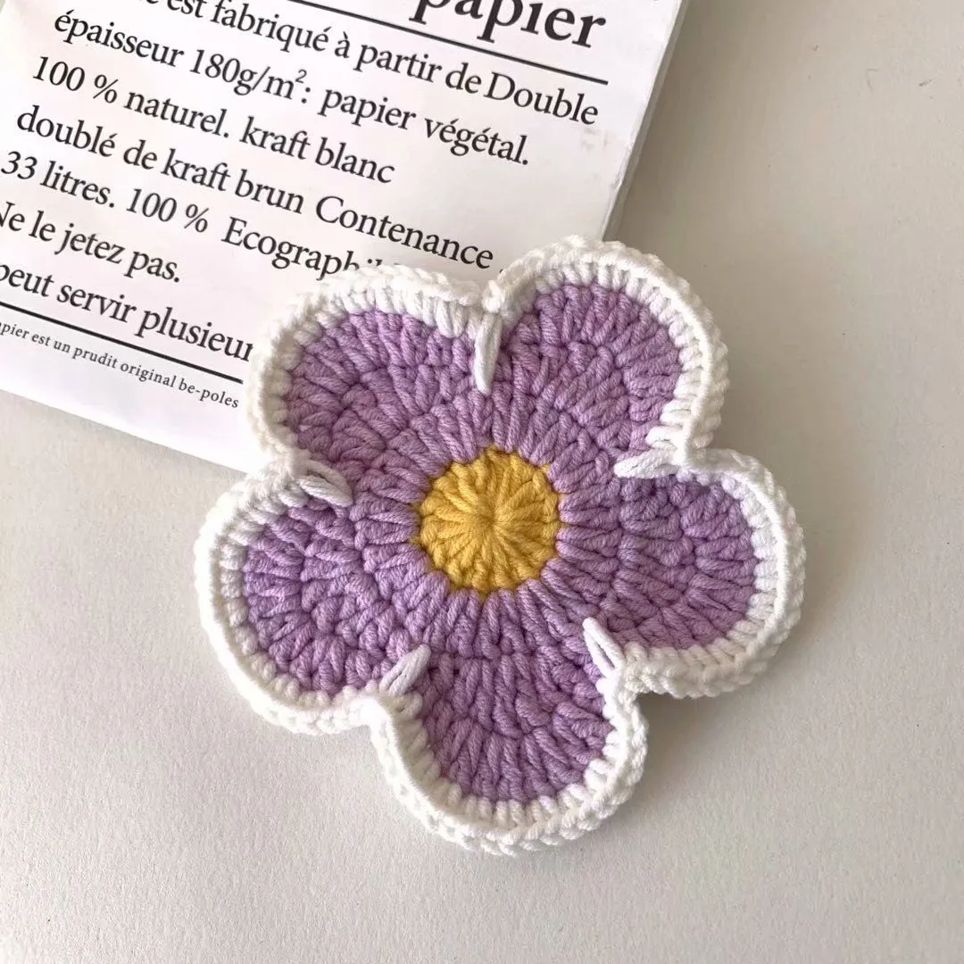 Set of five handmade woven cotton thread flower placemats in blue, green, orange, pink, and purple.