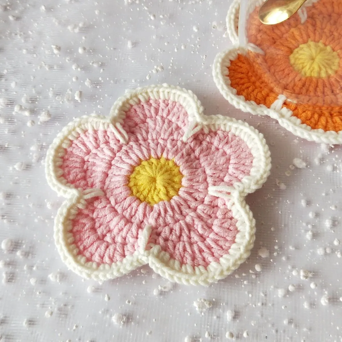 Set of five handmade woven cotton thread flower placemats in blue, green, orange, pink, and purple.