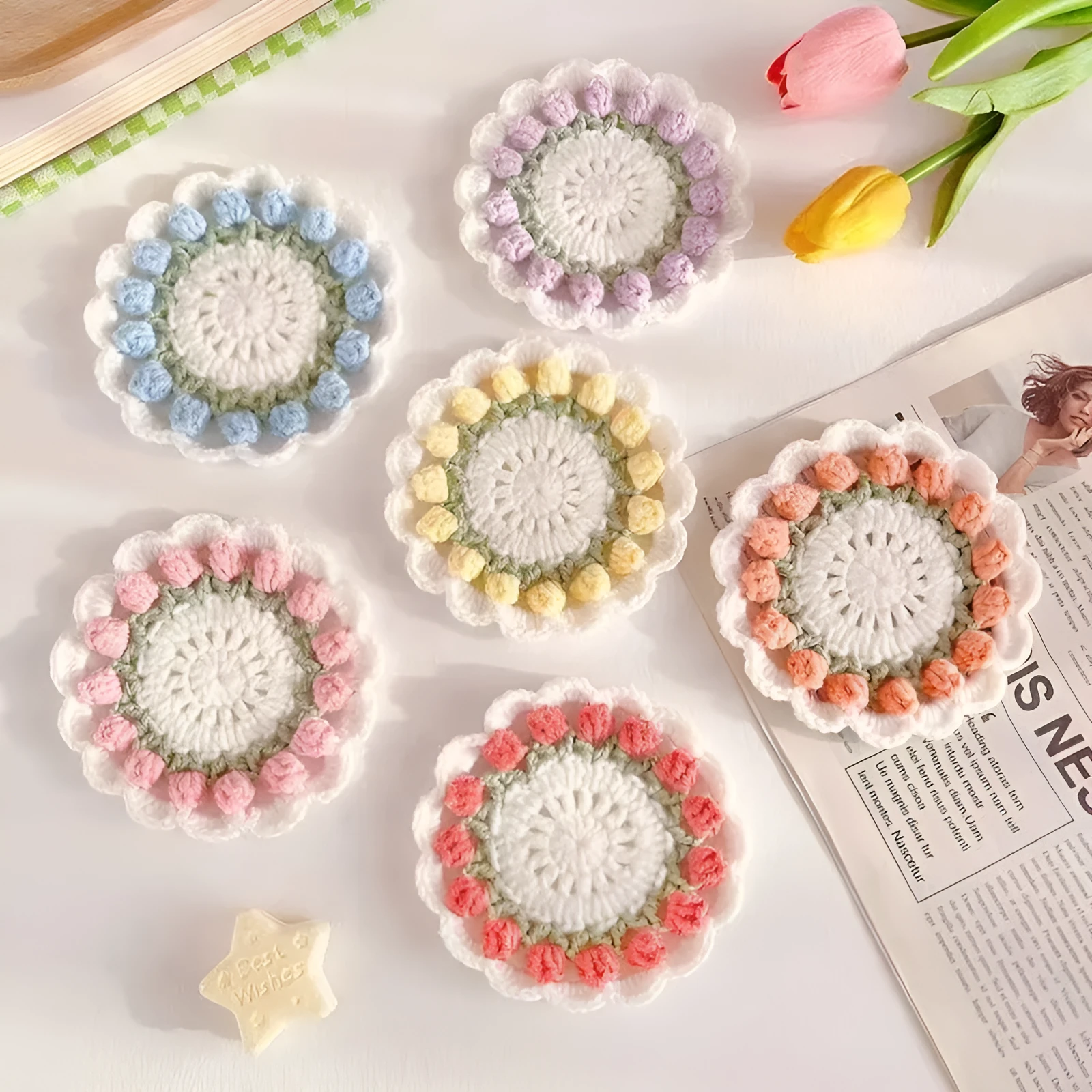 Handmade woven floral coaster in cotton and linen yarn on a wooden table
