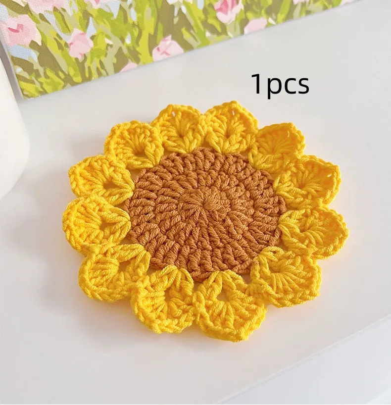 A hand-woven circular wool coaster with a floral pattern, shown as a single piece.