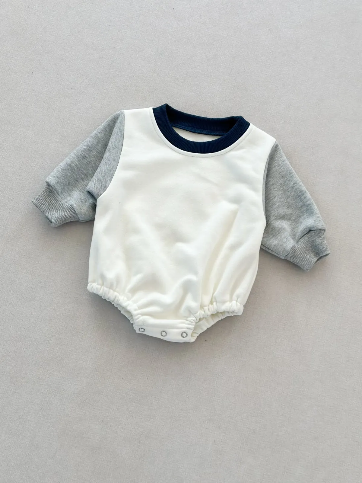 Baby romper in cotton triangle jumpsuit style with hidden hook closure, autumn weight, available in multiple colours