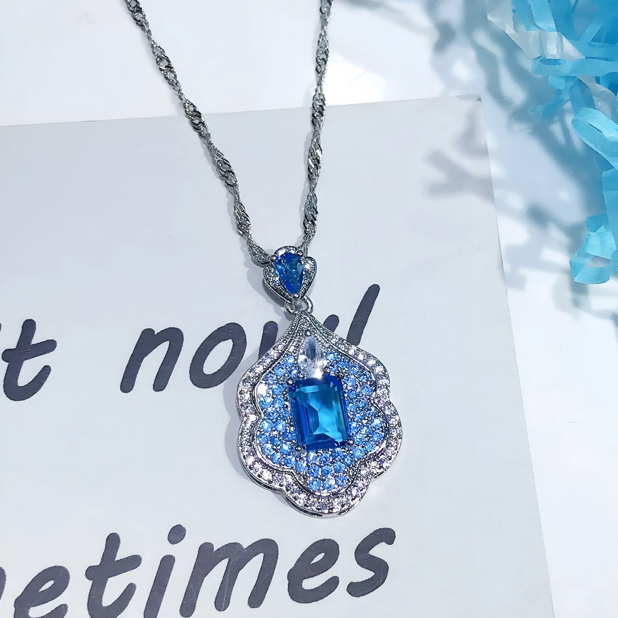 Sea blue geometric copper pendant charm with aquamarine topaz design, shown without a chain.