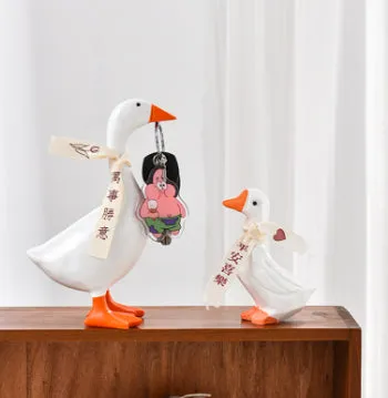 White simulation duck resin magnetic ornament on metal surface holding a note