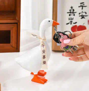 White simulation duck resin magnetic ornament on metal surface holding a note