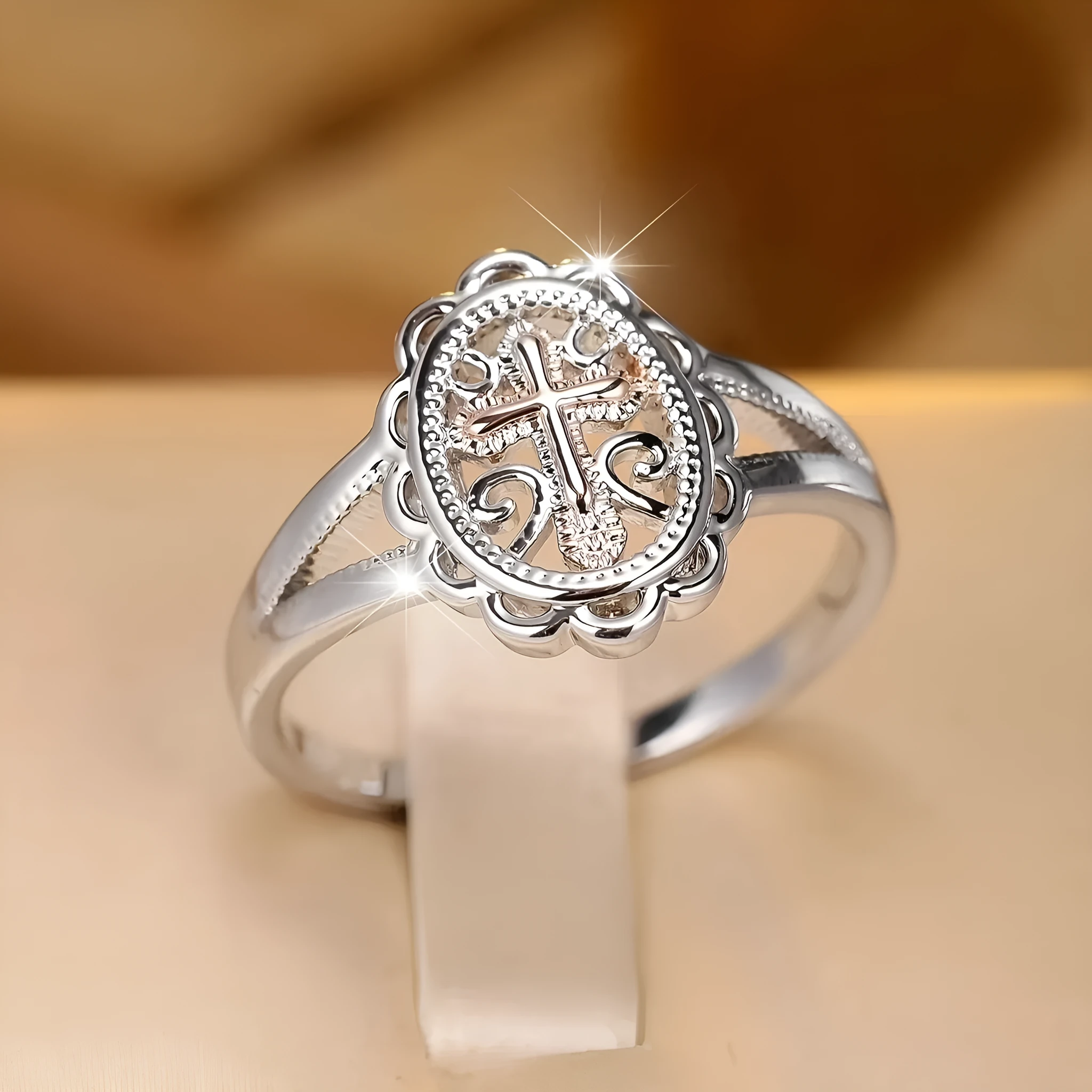 Silver cross and lace patterned alloy ring for women on a white background.