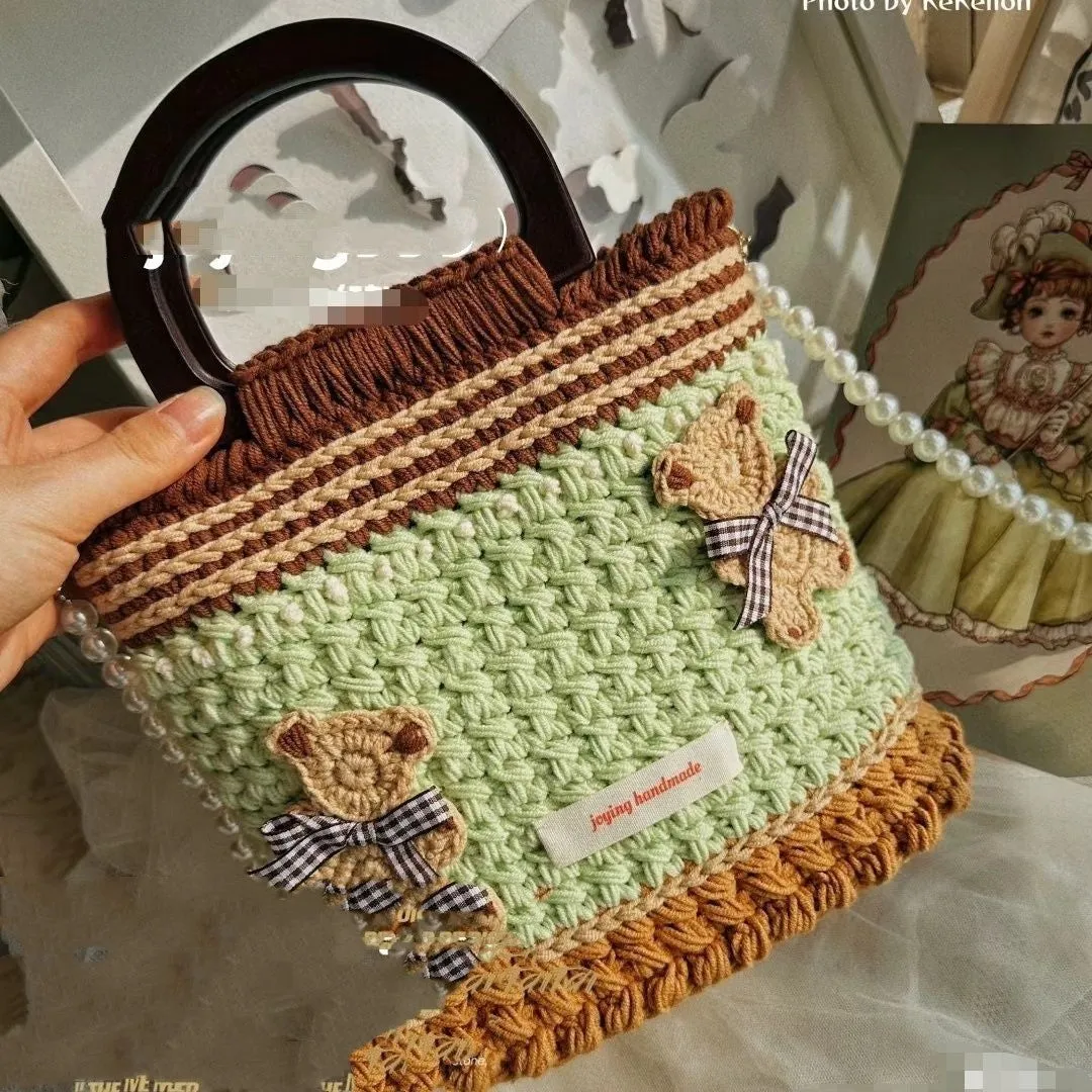 Wool crocheted bear shoulder bag with wooden handle and adjustable strap in one of four decorative styles