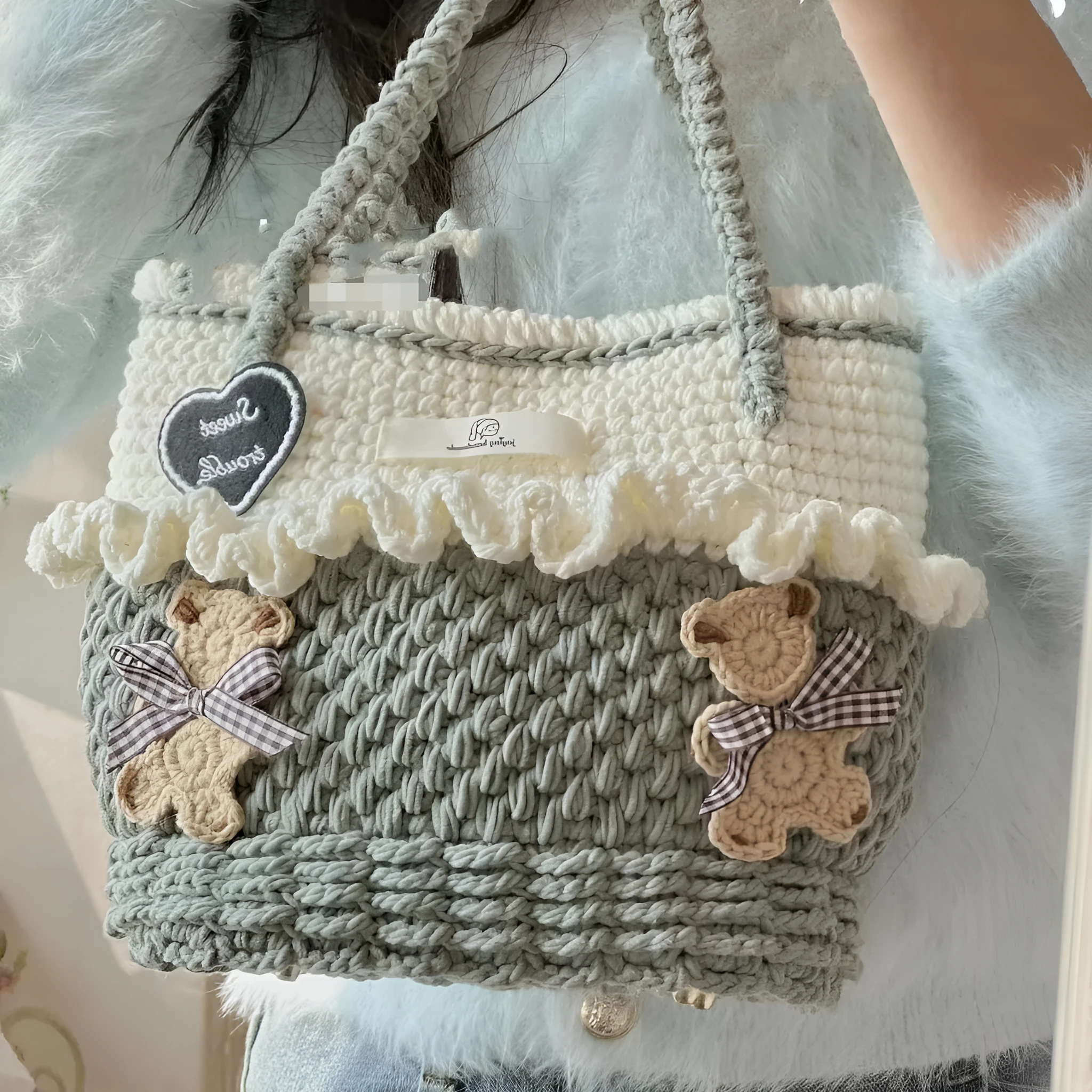 Wool crocheted bear shoulder bag with wooden handle and adjustable strap in one of four decorative styles