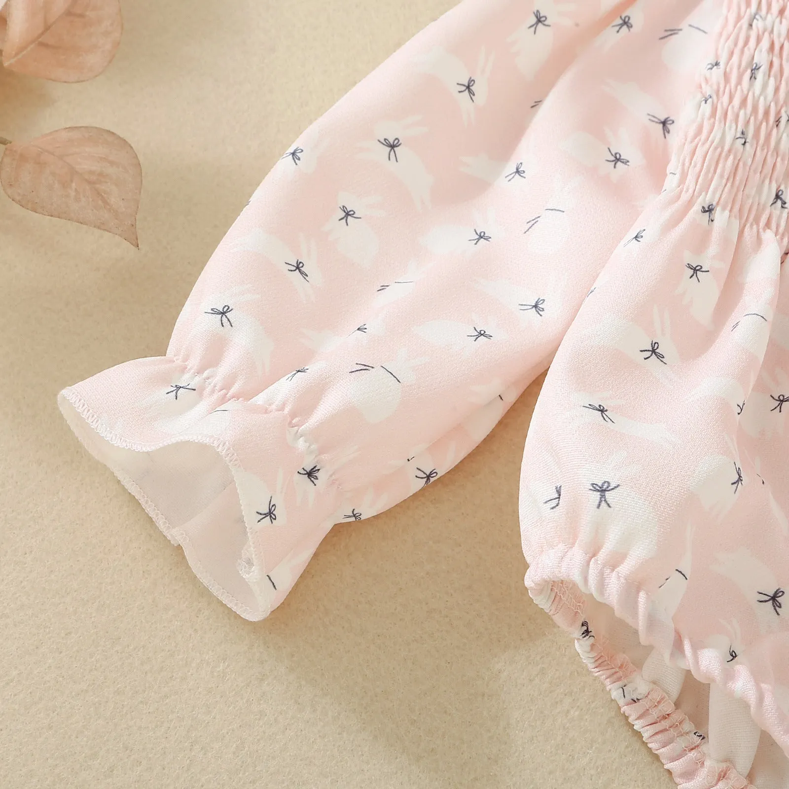 Pink infant cotton long sleeve romper with smocking and print on front for newborn baby girl