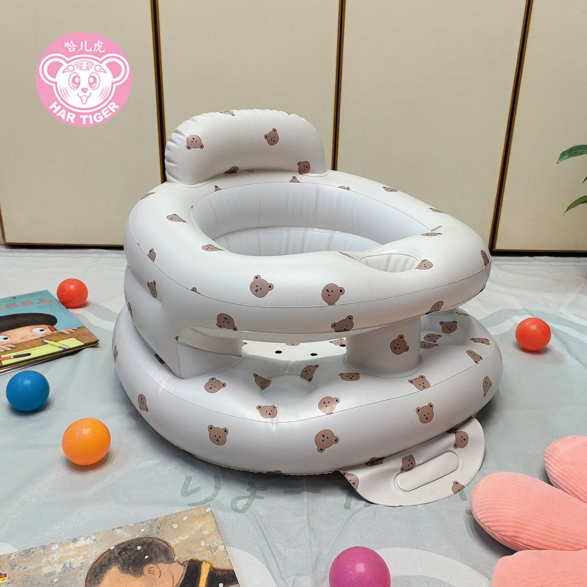 Inflatable infant dining chair in PVC with bear design, deflated beside a baby for scale