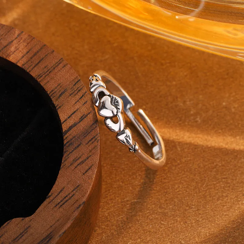 Retro silver women's open ring with a heart shape on a copper band.
