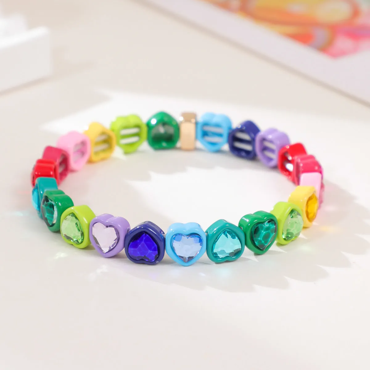 Rainbow coloured enamel heart pendant on stretch bracelet band
