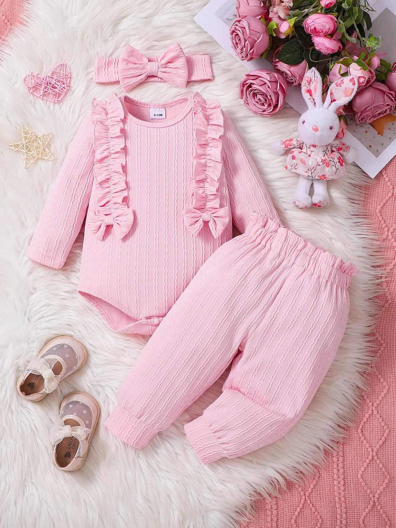 Pink baby girl three-piece set with ribbed frill long sleeve romper, pants, and matching headscarf on white background