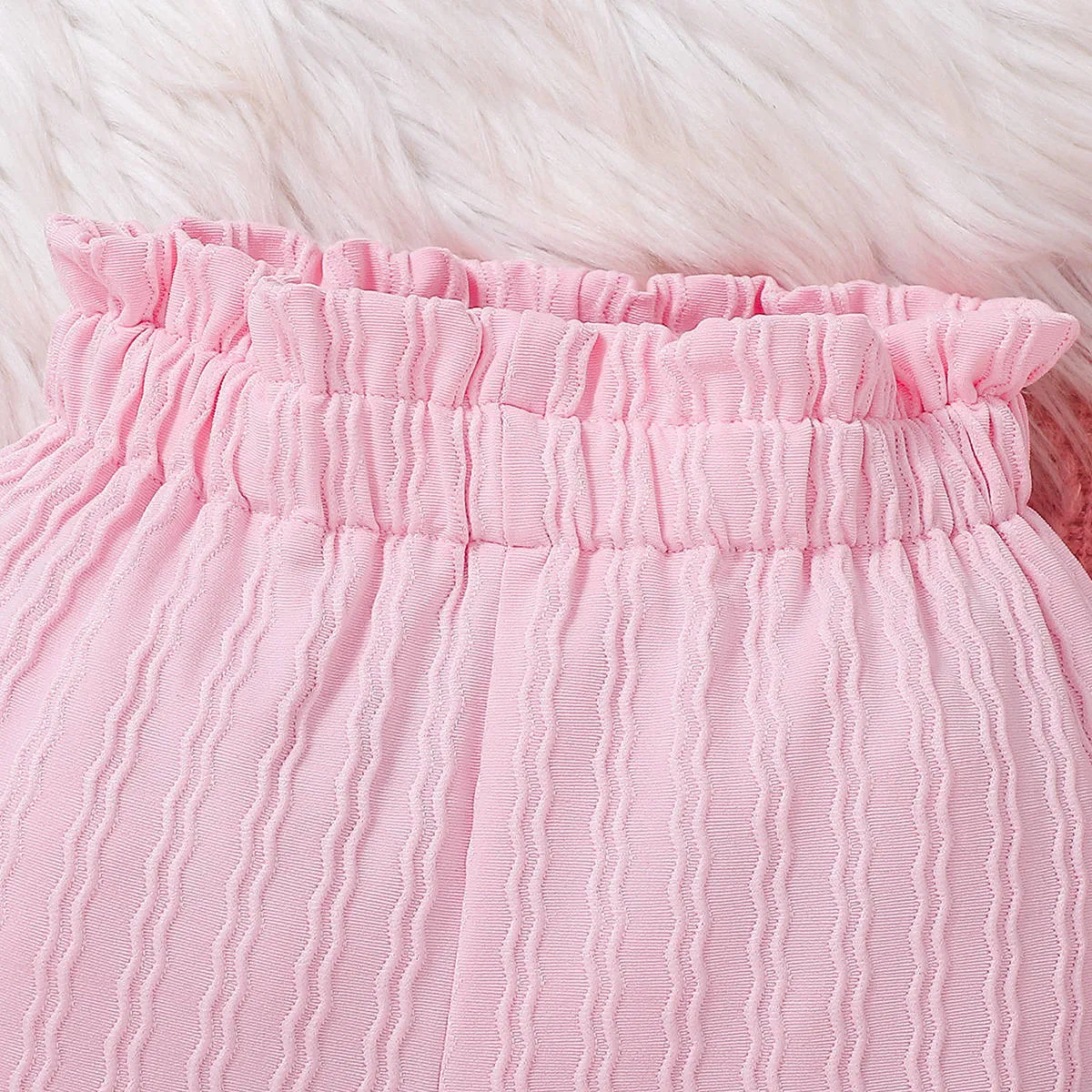 Pink baby girl three-piece set with ribbed frill long sleeve romper, pants, and matching headscarf on white background