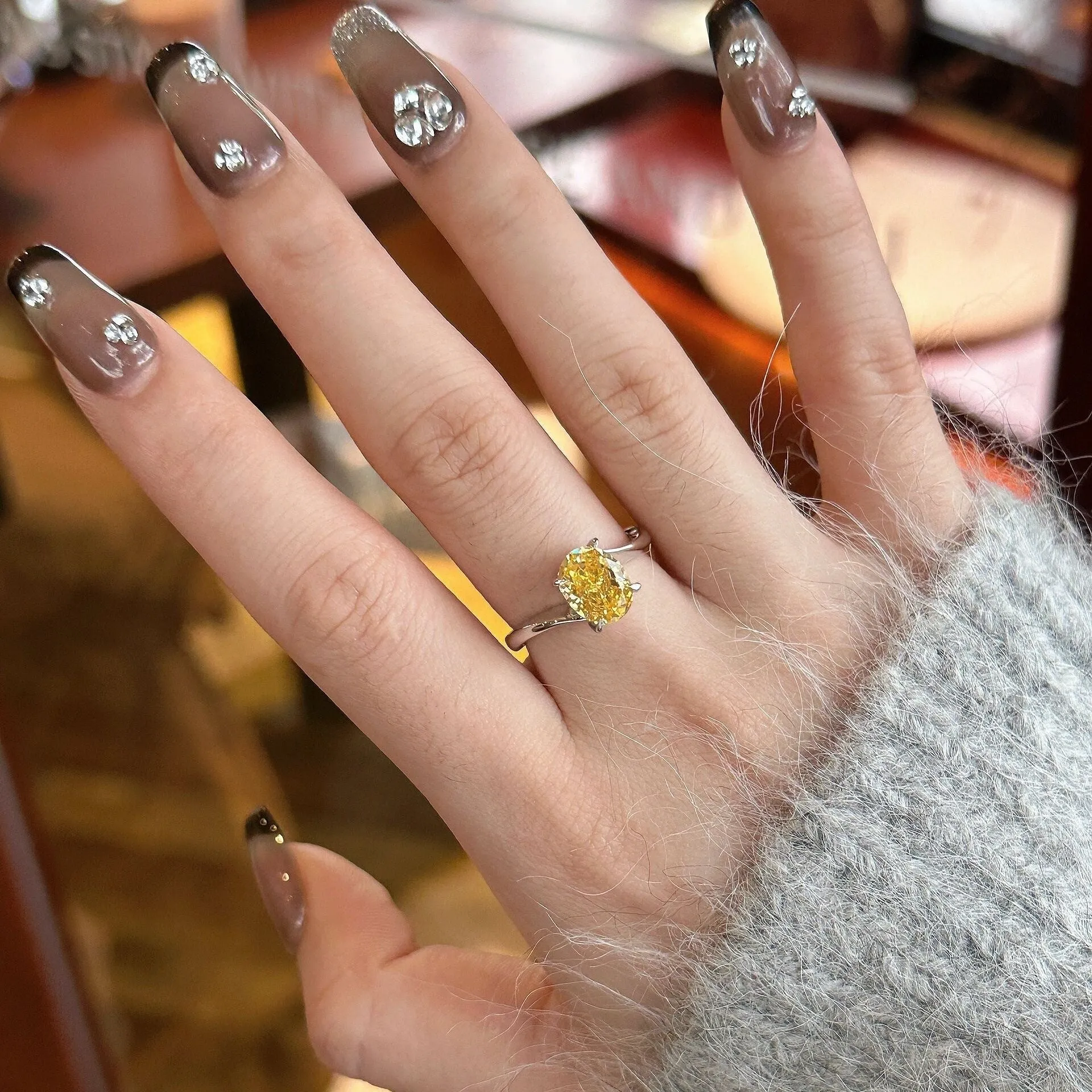 Women's copper ring with a bright yellow crystal sugar finish on a finger.