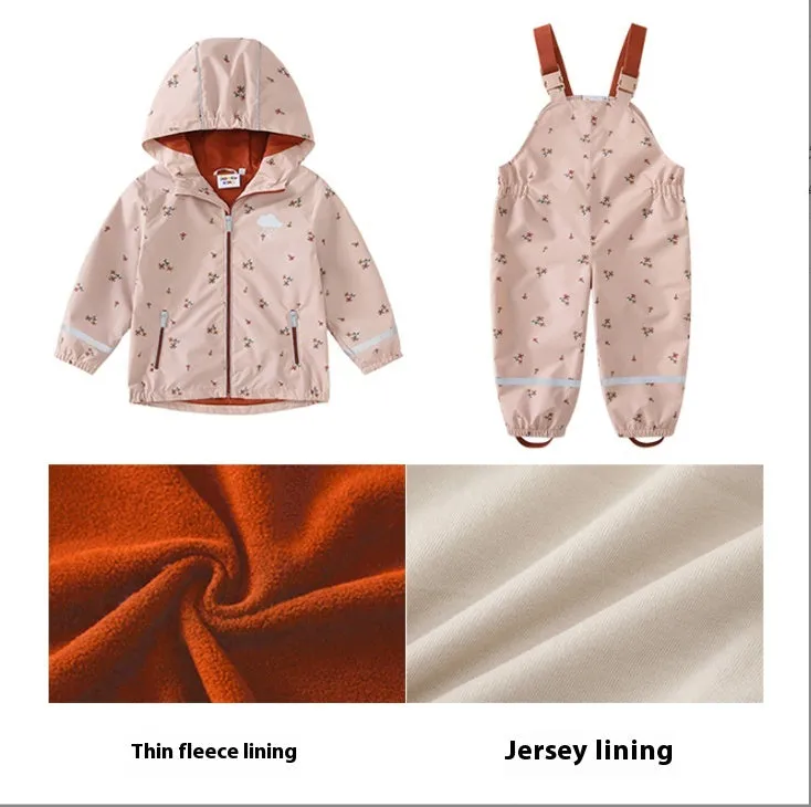 Pink floral children's rain jacket and pants set with hood, reflective details, and loose fit on a child outdoors