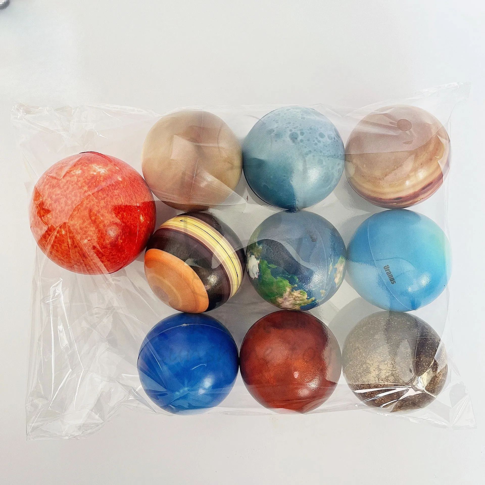 Set of eight solar system planet stress balls plus moon and sun in soft PU foam on white background