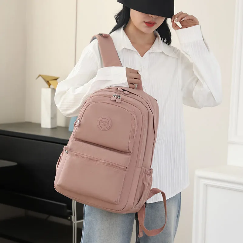 Women's nylon travel backpack in Azure Stone Green showing multiple compartments and organisational features