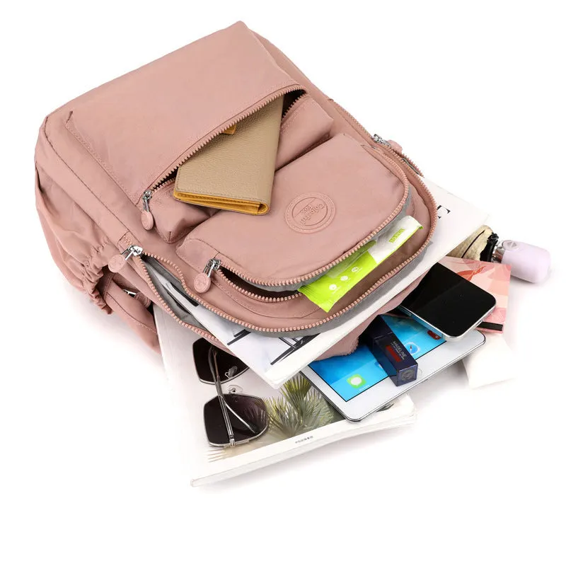 Women's nylon travel backpack in Azure Stone Green showing multiple compartments and organisational features