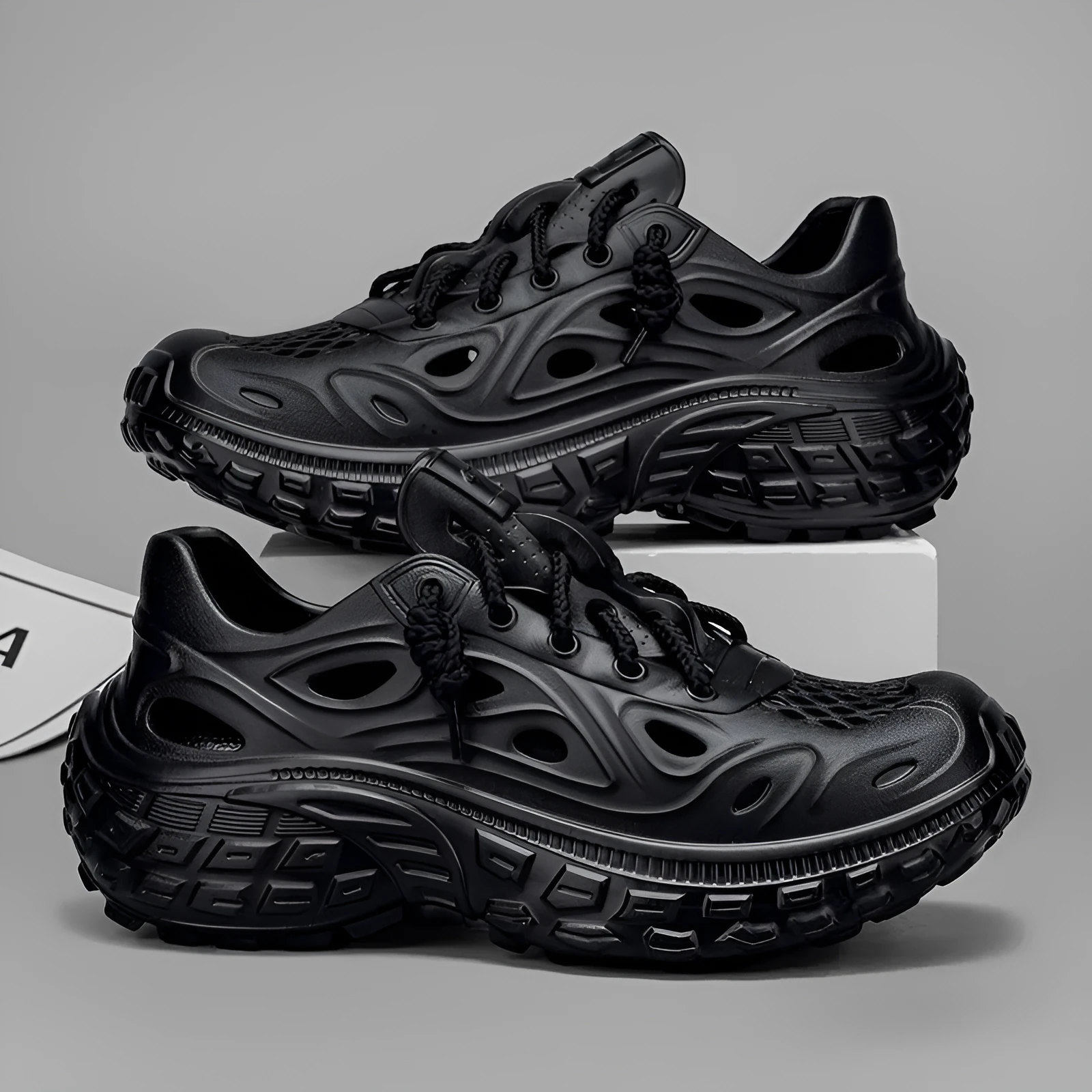 Men's black EVA sandals with a hollow out design and thick sole, shown on a foot.