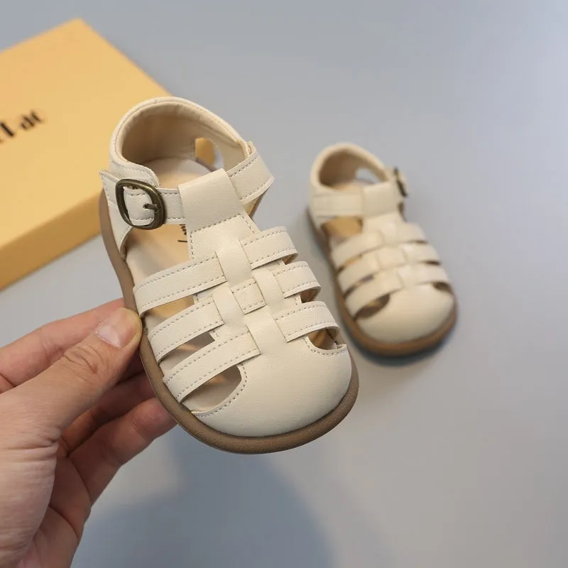 Girls' closed toe PU leather woven hollowed Roman sandals with Velcro strap, beige colour, on toddler feet