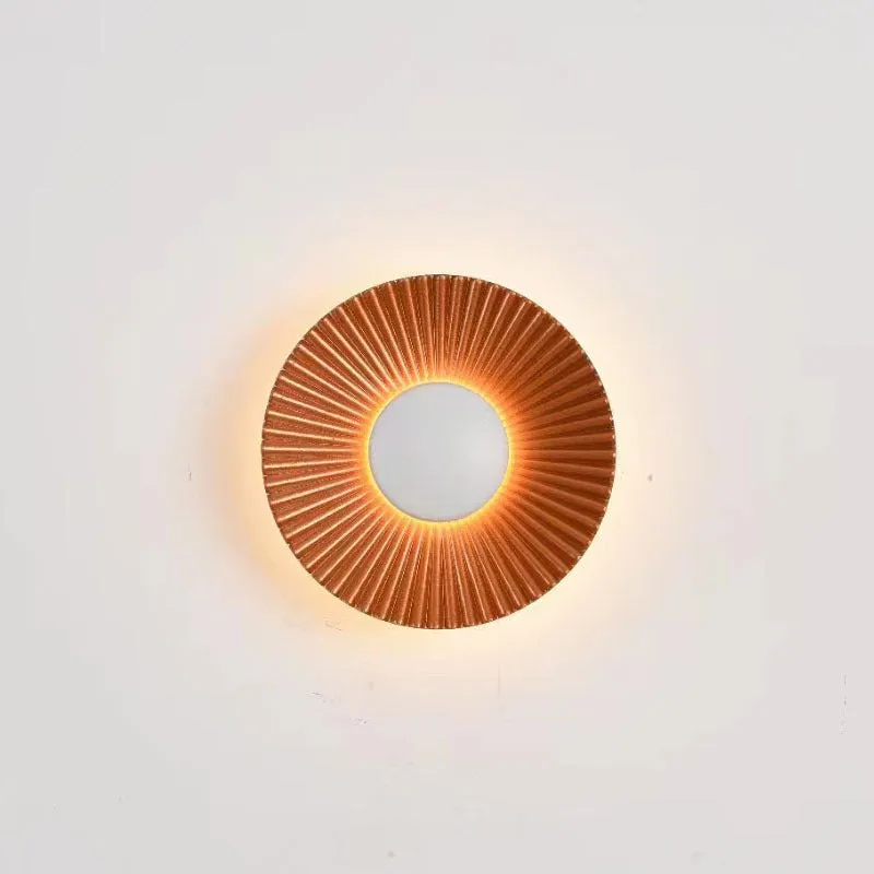 Round aluminium wall lamp in an outer white and inner gold colour combination, mounted on a wall.