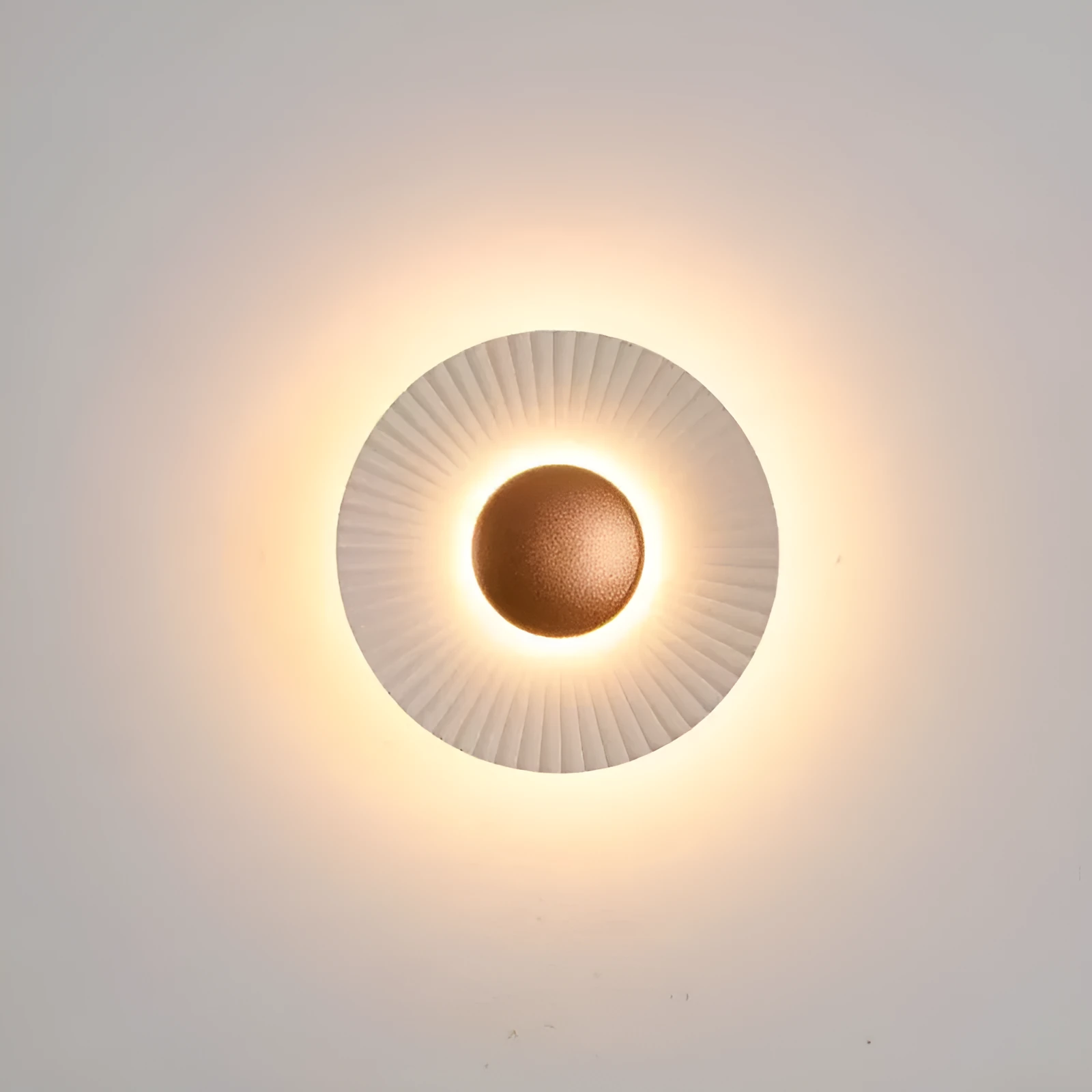 Round aluminium wall lamp in an outer white and inner gold colour combination, mounted on a wall.