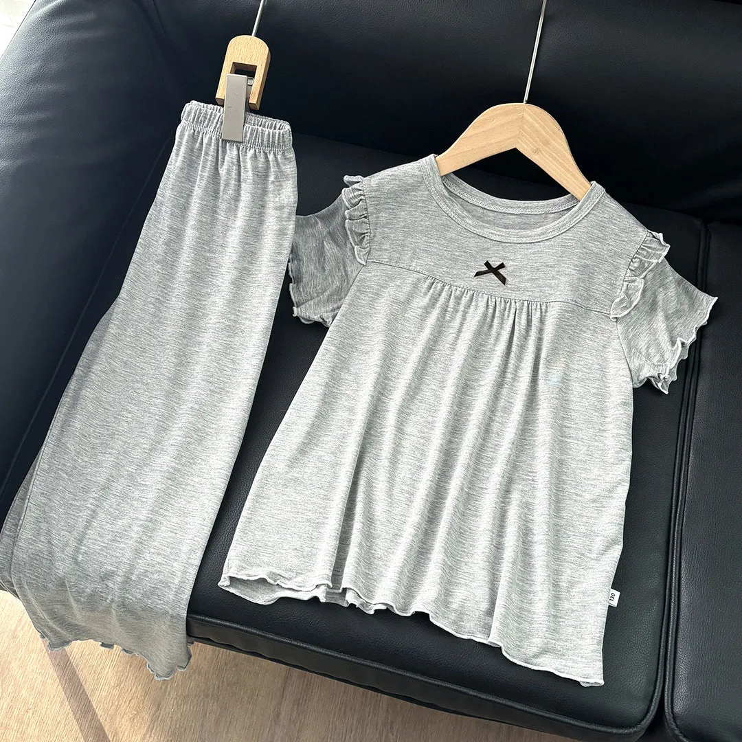 Girls' short sleeve modal pajama suit in solid colour, including top and pants, on a plain background