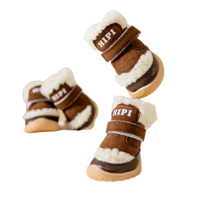 Brown winter dog shoes with adjustable Velcro straps and anti-slip rubber soles on a snowy surface