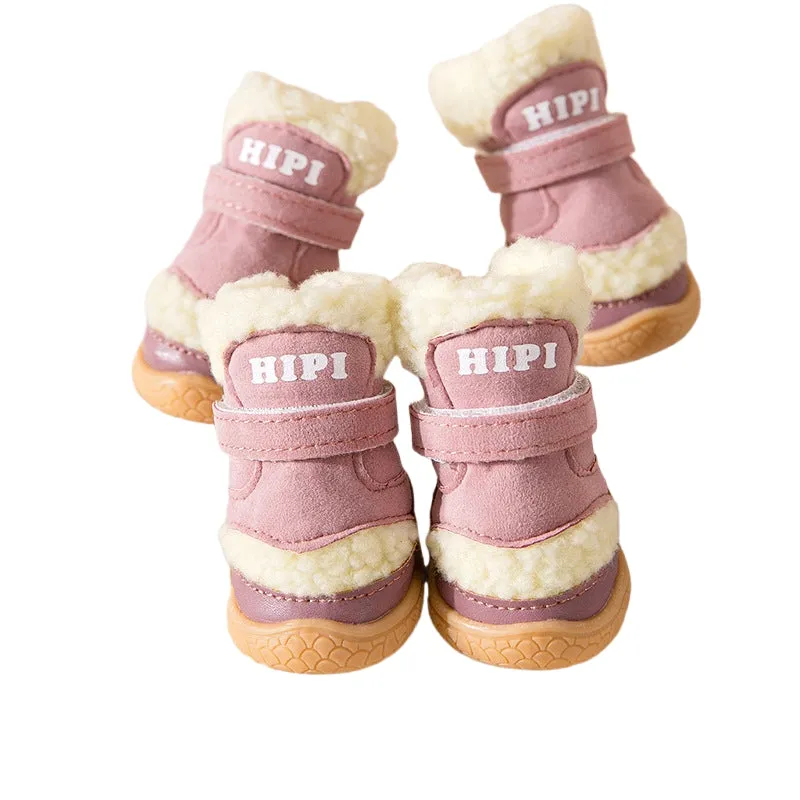 Brown winter dog shoes with adjustable Velcro straps and anti-slip rubber soles on a snowy surface