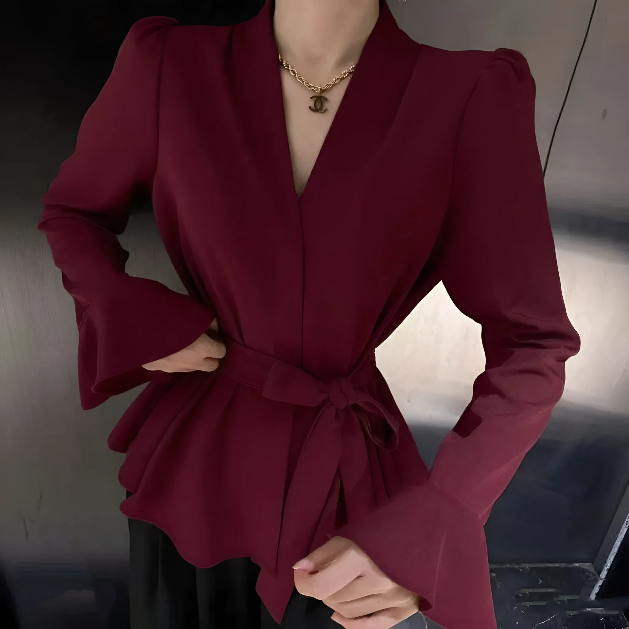 Women's black French-style shirt with long bell sleeves, an irregular collar, and a tied front detail.